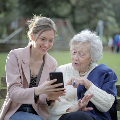 Junge Frau hilft Seniorin beim Bedienen eines Smartphones (Bildquelle: www.pexels.com)